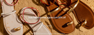Sandálias rasteiras brancas e marrons com detalhes metálicos dourados dispostas sobre areia, com texto promocional ao centro: “Suas flats favoritas, agora com 50% off” e chamada para ação “Confira a curadoria”.