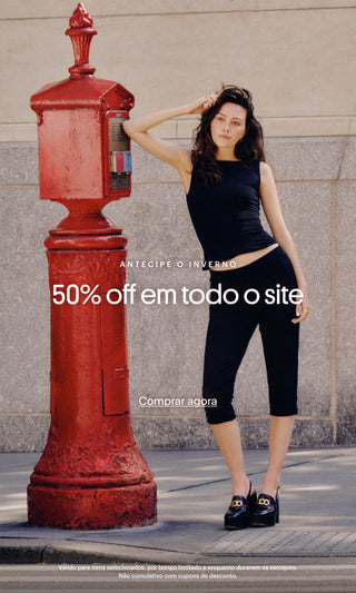 “Mulher vestindo conjunto preto encostada em um hidrante vermelho na calçada. Texto sobreposto: ‘Antecipe o inverno’, ‘50% off em todo o site’ e botão ‘Comprar agora’.”
