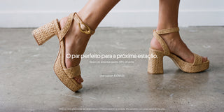 Close nas pernas de uma mulher usando sandálias de salto bloco em ráfia bege com fivela dourada sobre piso de concreto. Banner promocional com o texto "O par perfeito para a próxima estação. Quem se antecipa ganha 20% off extra." e chamada para usar o cupom EXTRA20.