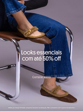 Sapatilha marrom com acabamento em shearling e fivela dourada sendo usada com jeans, destacando a campanha de até 50 por cento de desconto em looks essenciais