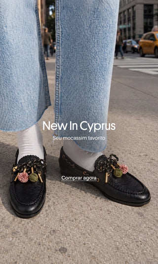 Mocassins de couro preto Cyprus com pompons coloridos, usados com meias brancas e jeans. New In Cyprus — Seu mocassim favorito. Comprar agora.
