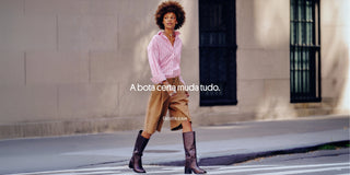 Bota cano longo preta com look casual de saia midi caramelo e camisa listrada rosa