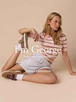 Modelo usando tênis George Larroudé bege em fundo neutro com destaque para o novo lançamento.